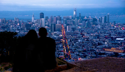 Rear view of couple overlooking cityscape