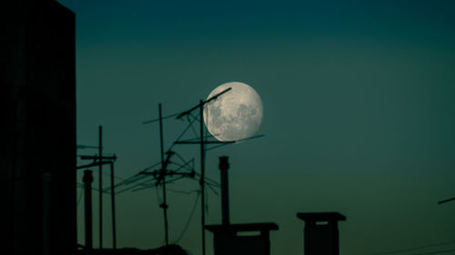 Low angle view of communications tower against sky at night