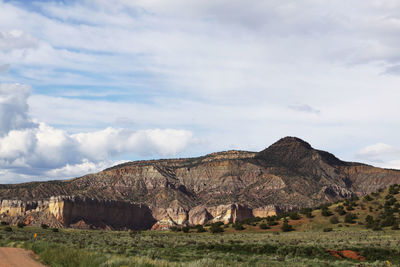 View of rocky mountains against cloudy sky
