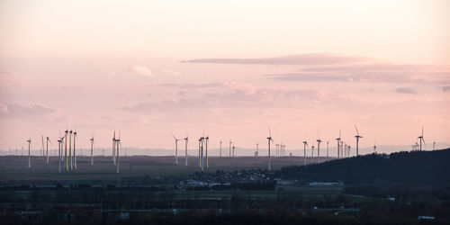 Traditional windmill against sky during sunset