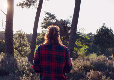 Rear view of woman standing by tree