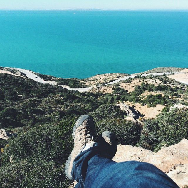 low section, person, sea, blue, lifestyles, water, leisure activity, personal perspective, tranquility, tranquil scene, standing, men, beach, scenics, beauty in nature, nature, relaxation, shoe