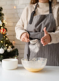 Smiling woman in the kitchen baking christmas cookies