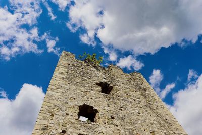 Low angle view of old building against cloudy sky