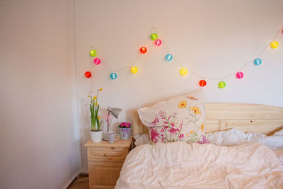 Multi colored flowers on bed against wall at home