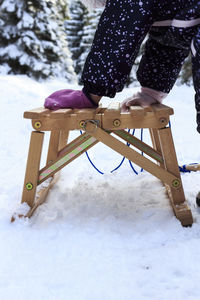 Low section of woman with snow covered umbrella