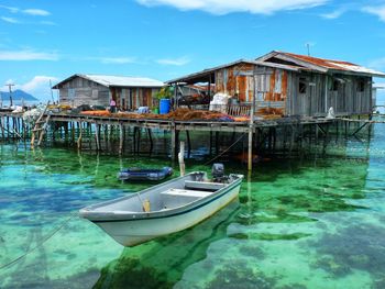 Boats in lake by houses against buildings