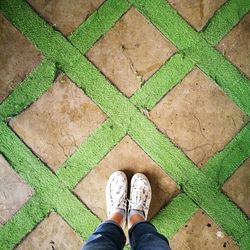 Low section of man standing on tiled floor