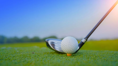 Low section of person playing golf ball on field