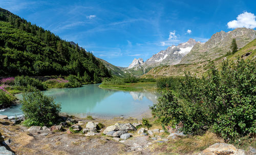 Scenic view of lake by mountains against sky