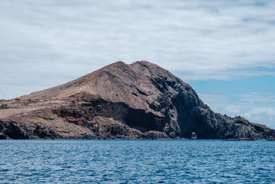 Rock formations by sea against sky