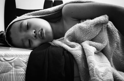 Close-up of boy sleeping on bed at home