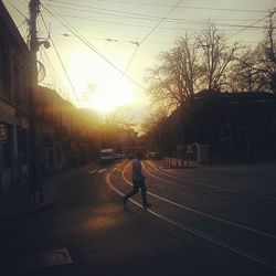 Road passing through city at sunset