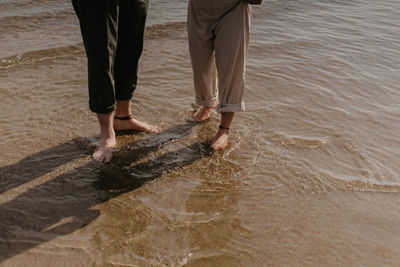 Low section of man standing in water