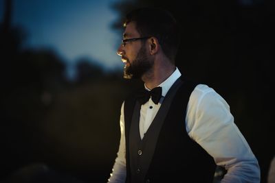 Handsome young man looking away at night