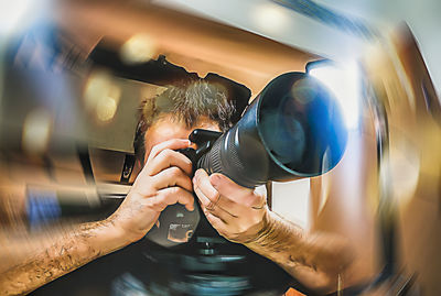 Portrait of man photographing through camera