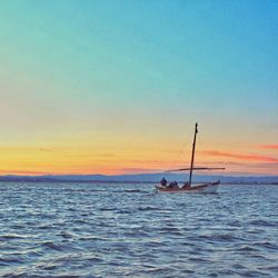 Boats in sea at sunset