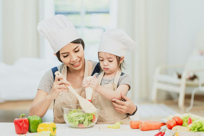 Woman holding ice cream in kitchen