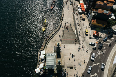 High angle view of people on street by river in city during sunny day