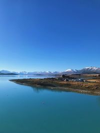 Scenic view of lake against clear blue sky