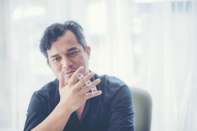 Thoughtful businessman holding dices in office