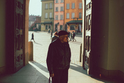 Rear view of man walking on street in city