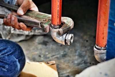 Low section of man working on metal