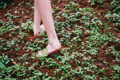 Low section of woman walking on field