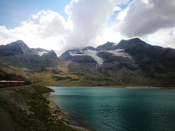 Scenic view of mountains and lake against cloudy sky