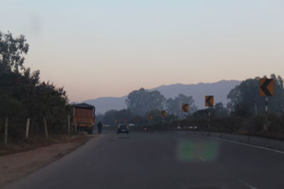 Road in city against clear sky during sunset