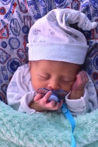 Midsection of baby girl lying on bed