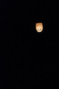 Low angle view of illuminated lamp against dark sky