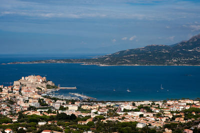 High angle view of townscape by sea against sky