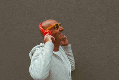 Portrait of man wearing sunglasses against wall