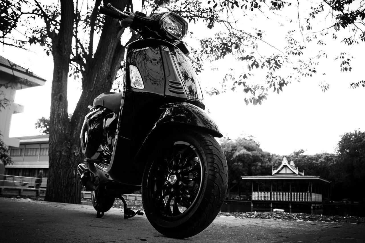 SIDE VIEW OF MAN RIDING MOTORCYCLE AGAINST SKY IN CITY