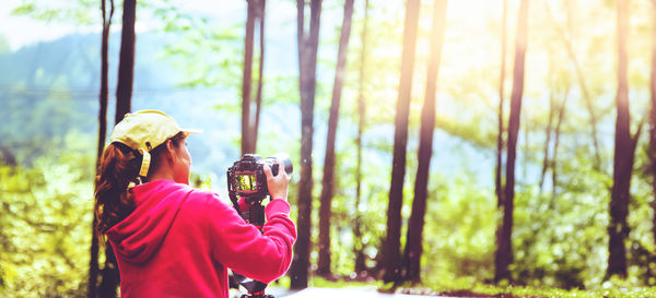 Rear view of woman standing in forest