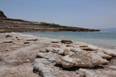 Rocks on beach against clear sky