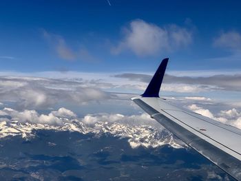 Airplane flying over clouds against blue sky