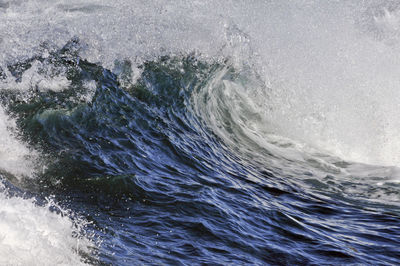 High angle view of waves splashing in sea against sky