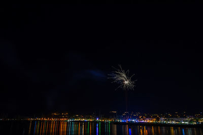 Firework display over city at night