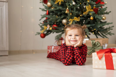 Portrait of smiling girl decorating christmas tree