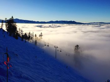 Scenic view of snow covered mountains against blue sky