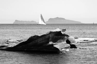 Sailboat sailing on sea against clear sky