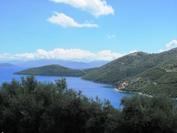 Scenic view of lake and mountains against blue sky