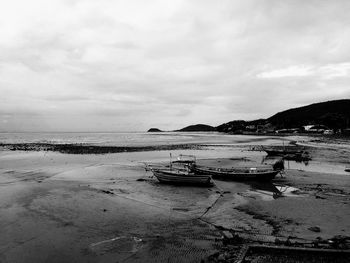 Boats moored on beach against sky