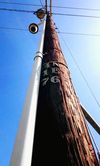 Low angle view of power lines against blue sky