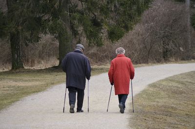 Rear view of senior couple walking on road