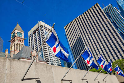 Low angle view of flags against buildings in city