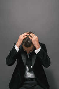 Midsection of man wearing hat against wall