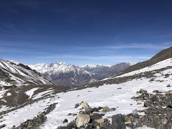 Scenic view of snowcapped mountains against blue sky